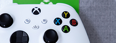 ภาพจอย Xbox Series S สีขาวระยะใกล้บนพื้นหลังสีขาวและเขียว
