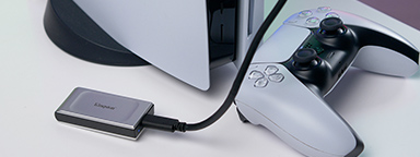 Konsola PlayStation5, kontroler i zewnętrzny dysk SSD Kingston XS2000 podłączony do gniazda USB.