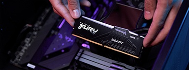 uma mão instalando Kingston FURY Beast DDR5 RGB em uma placa-mãe de PC