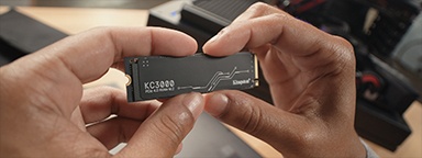 KC3000 NVMe SSD を持つ手のクローズアップ。