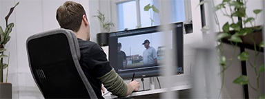 Un designer multimediale mentre monta un video alla sua scrivania