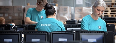 Team del magazzino Signpost che prepara i laptop per la consegna