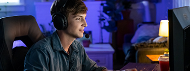 어두운 방에서 PC로 게임을 하고 있는 젊은 남자.