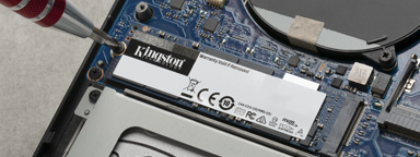 Disque SSD M.2 de Kingston en cours d'installation dans un ordinateur portable