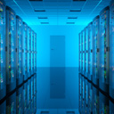 View down a data center hallway with blue lighting and green LEDs