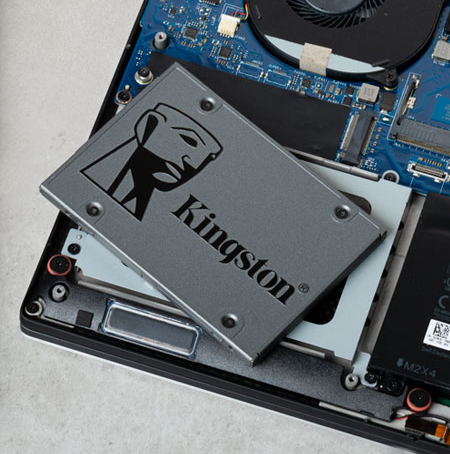 SSD storage drive on top of a disassembled laptop PC