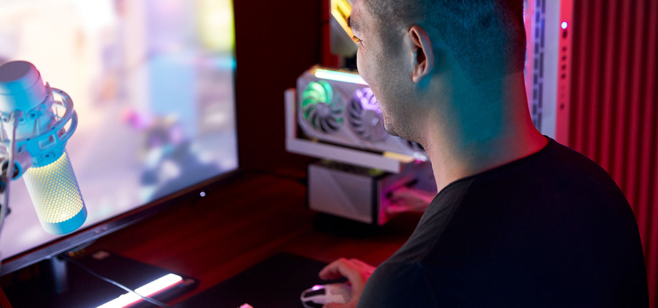 Gamer menikmati game tembak-menembak orang pertama (FPS/fist-person shooter) dengan perlengkapan gamer RGB. 