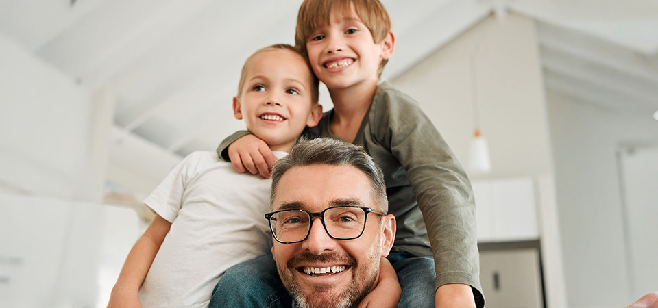 Organizing a media collection to be family-friendly means making decisions about what is appropriate for different age groups. A father and two children on a couch together.
