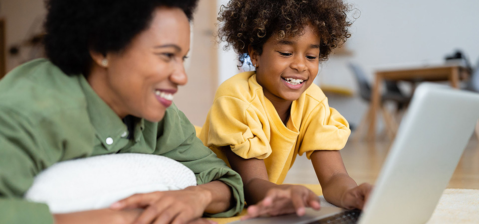 Assembling a media collection means making choices about what to include but also exclude. A mother and child use a laptop together in their living room.