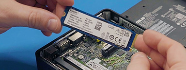 Un employé de SNUC est en train d’installer un SSD et un module DRAM de marque Kingston dans un ordinateur compact.