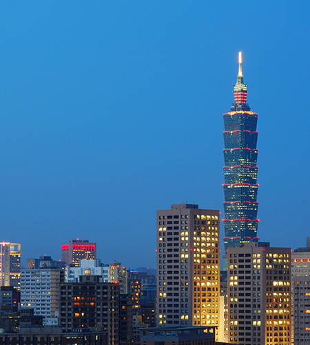 黄昏时分，台北的天际线尽收眼底，摩天大楼亮起，台北 101 高耸在城市的金融区上空。 