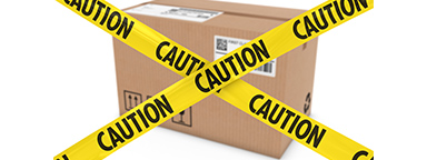 Kotak pengiriman dengan lakban peringatan