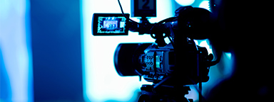 Un vidéaste examine des séquences sur une caméra vidéo avec plusieurs accessoires