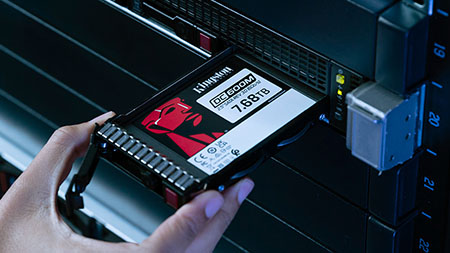 Qualcuno inserisce un drive SSD Kingston DC600M nell'alloggiamento di un server.