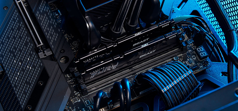 Interior de un PC con dos m&oacute;dulos Kingston FURY Beast instalados en una placa MSI con CPU refrigerada por l&iacute;quido y luz turquesa. 