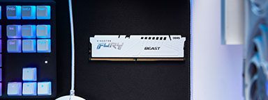 A white Kingston FURY memory module sits on a desktop next to a mouse and keyboard.