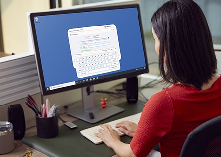 uma jovem em sua mesa com uma tela de login de admin de segurança em seu monitor