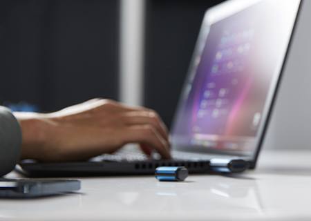 Eine Hand tippt auf einer Laptop-Tastatur, an die ein Kingston IronKey VP50 angeschlossen ist