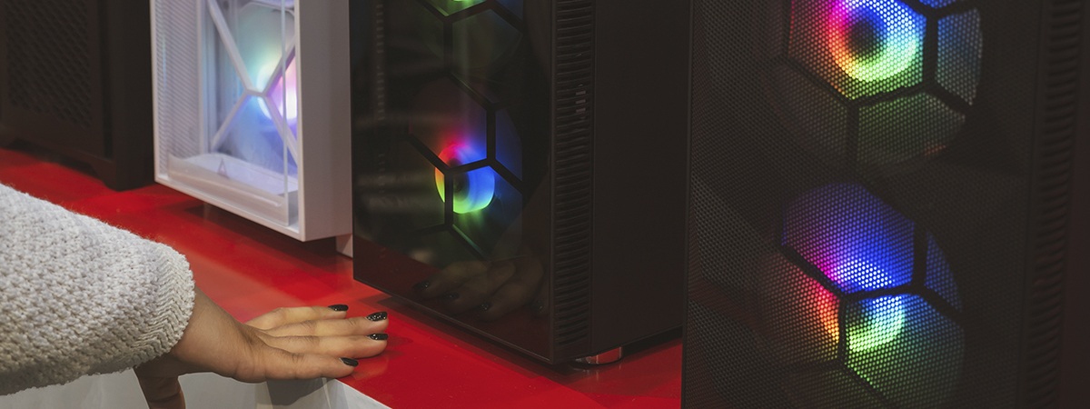 Carcasas de PC para juegos preensamblados expuestas en una tienda con la mano de una chica en primer plano