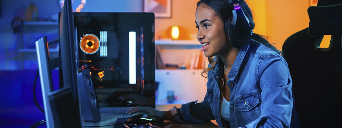 Gamerin mit Kopfh&ouml;rern, die auf ihrem Computer ein Videospiel spielt