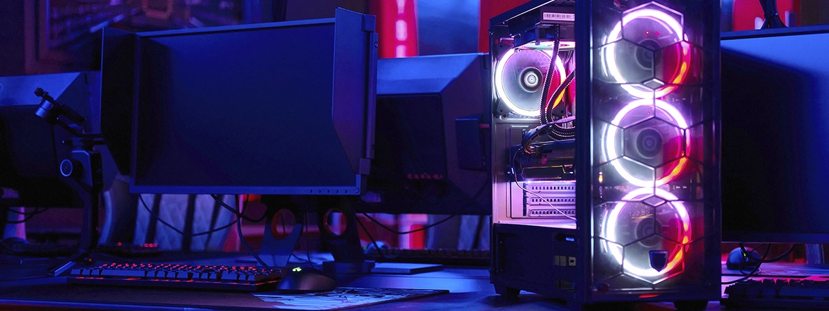 Nahaufnahme eines High-End-Gaming-PCs mit mehreren L&uuml;ftern auf einem Schreibtisch in einem dunklen Raum