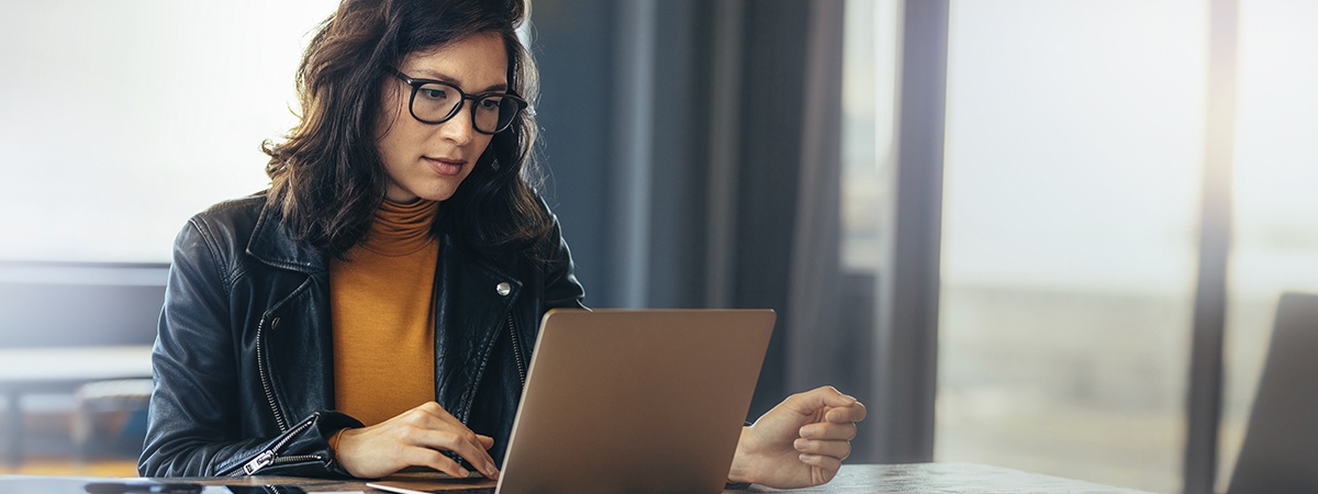 Una donna seduta a una scrivania in ufficio che digita sul suo laptop