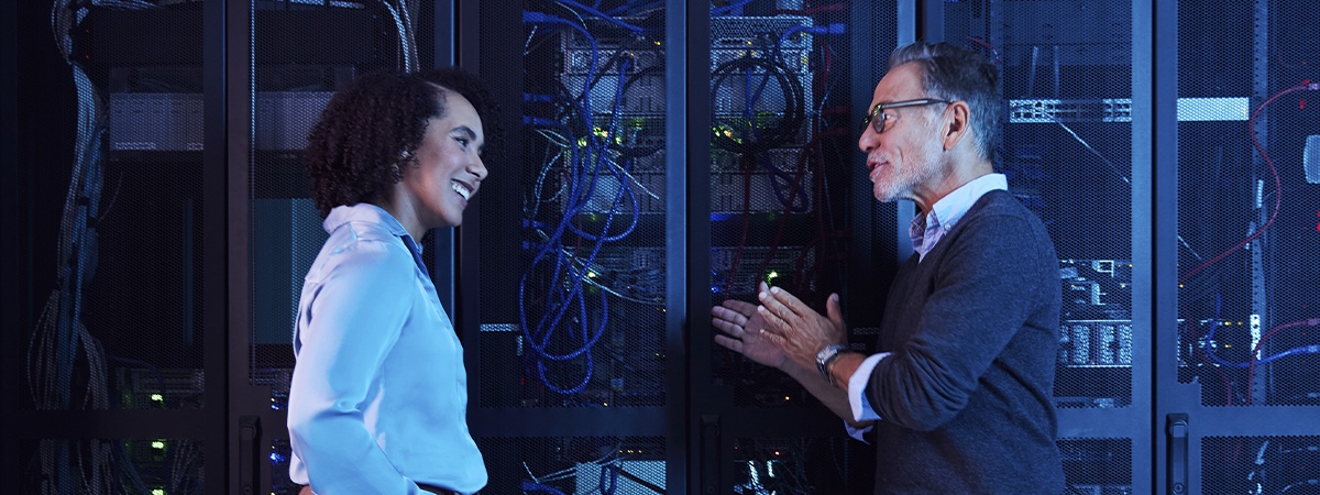Un ingegnere e un tecnico discutono della manutenzione dei server nel corridoio di un data center