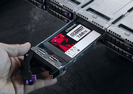 Kingston DC600M SSD'yi bir sunucu rafına takan bir el