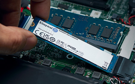 uma mão insere um SSD M.2 NVMe em uma placa-mãe