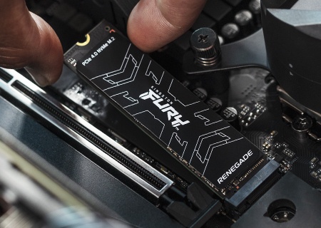 Крупный план руки, устанавливающей твердотельный накопитель FURY Renegade NVMe компании Kingston в системную плату компьютера