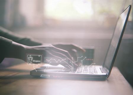 一只手在笔记本电脑键盘上打字，其中包含与电路线相连的金士顿固态硬盘、内存插图