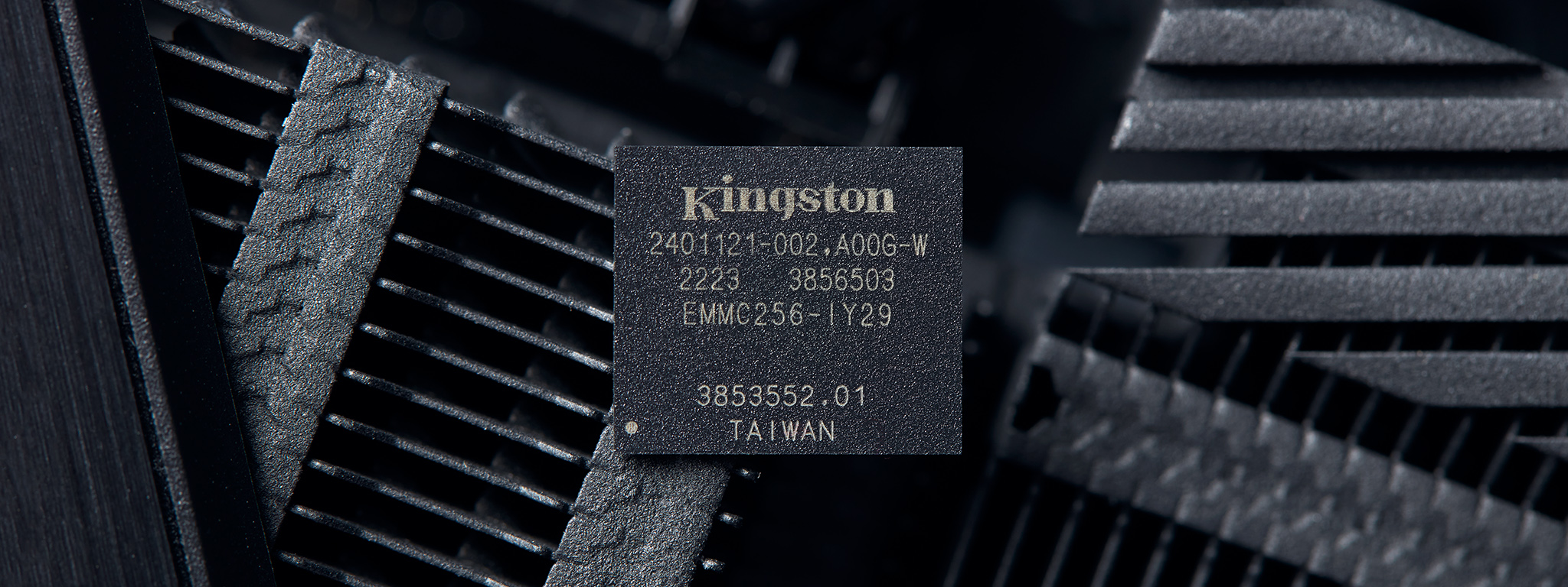 Unit eMMC Kingston dengan latar belakang casing komputer hitam.