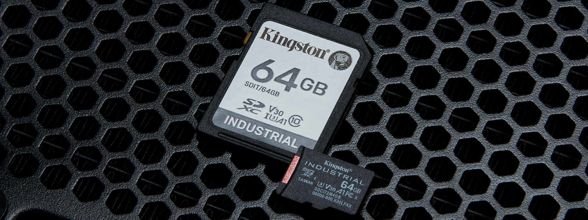 Immagine raffigurante una coppia di schede microSD Industrial Kingston da 64 GB posizionate su una superficie di metallo usurata