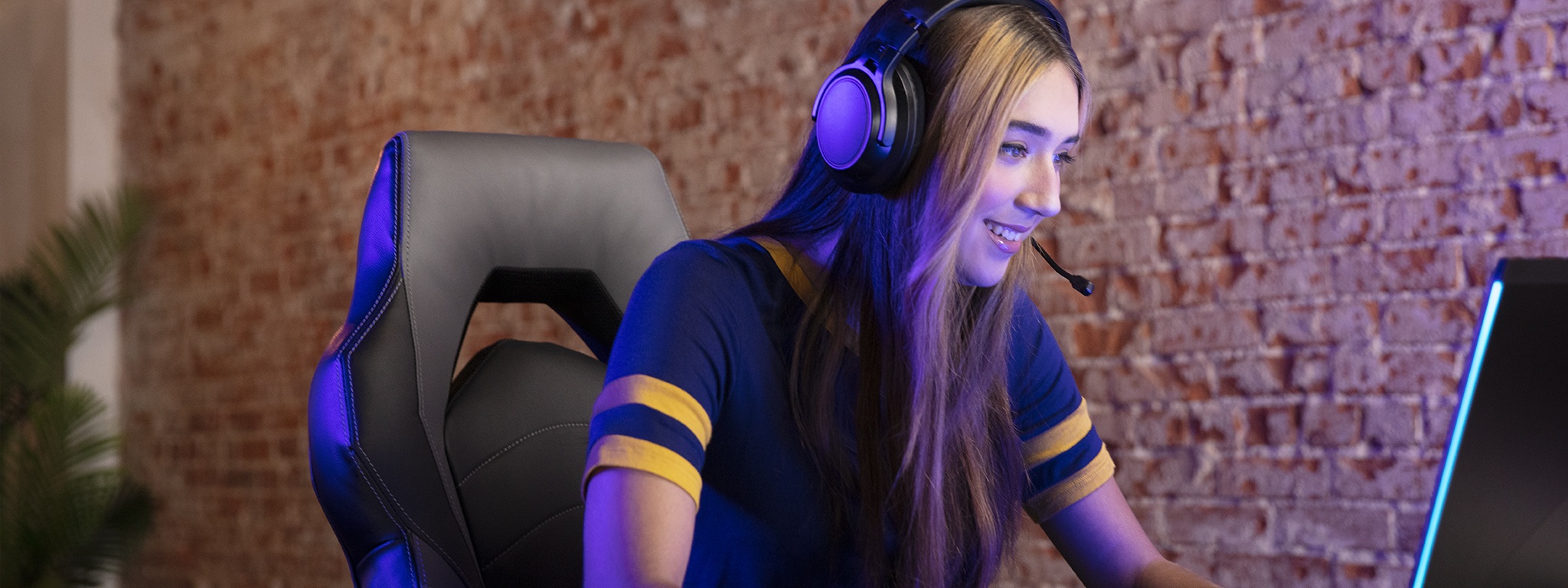 a girl wearing a headset looking at a monitor