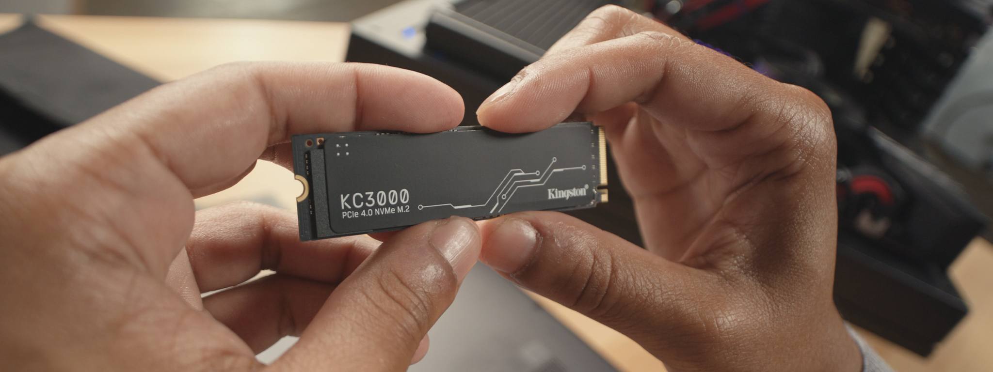 a close-up on hands holding KC3000 NVMe SSD