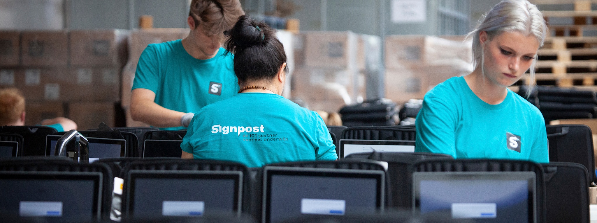 El equipo de almacenes de Signpost configurando portátiles para su envío