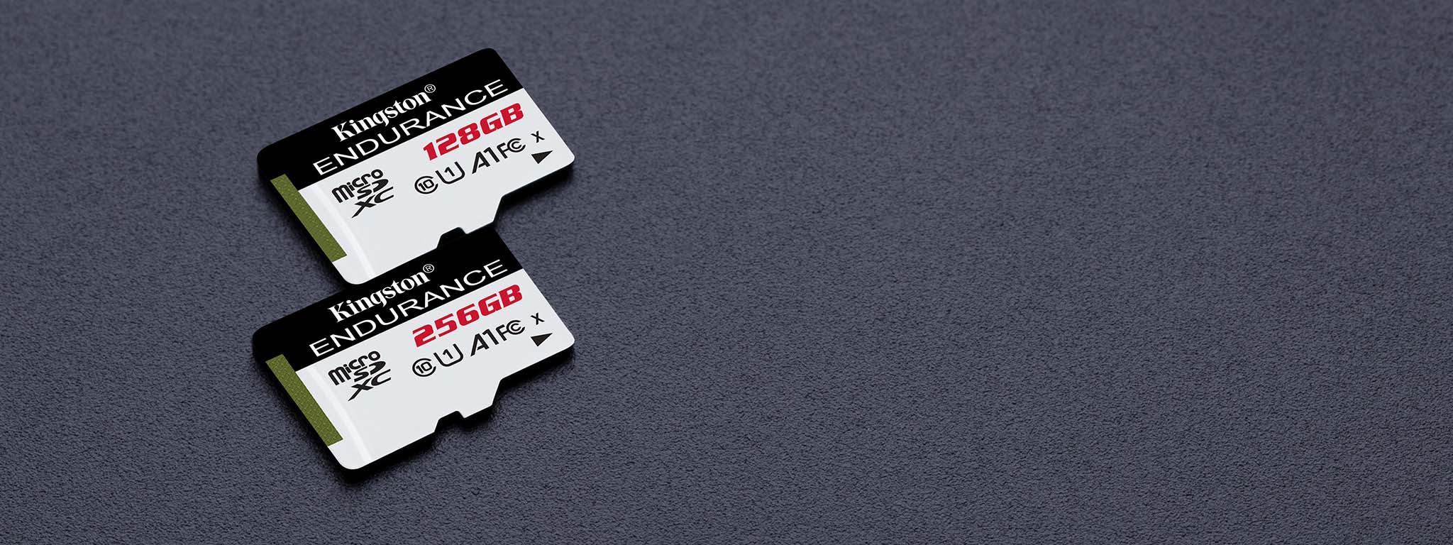 Para kart microSD High-Endurance o pojemności 128GB i 64GB leżących na czarnej powierzchni