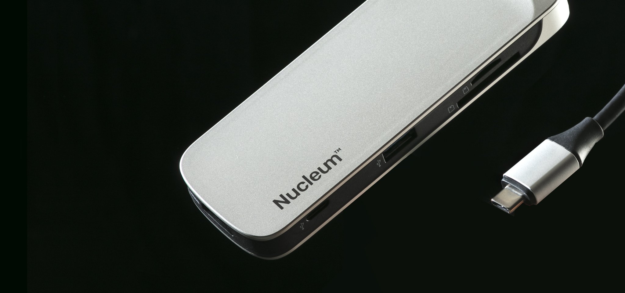 Hub dan pembaca kartu USB-C Nucleum terlihat pada posisi miring dengan latar belakang hitam pekat