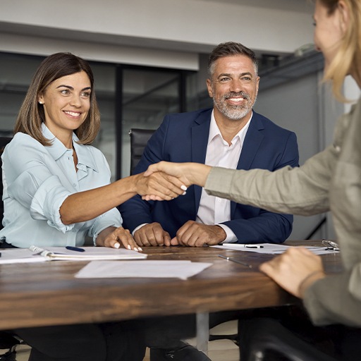 Two colleagues in a meeting with a business partner in an office room