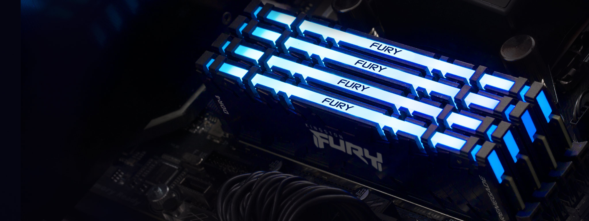4 модулі пам’яті Kingston FURY Renegade DDR4 RGB, що світяться синім кольором, встановлені в слоти пам’яті на материнській платі