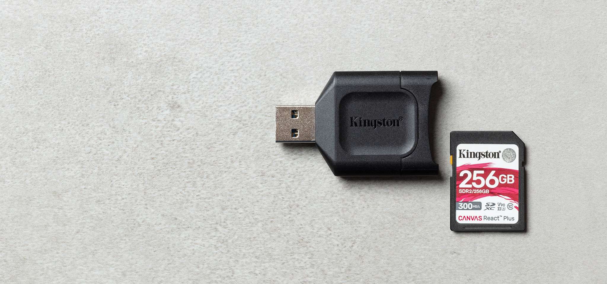 一台 MobileLite Plus SD 讀卡機放置在灰色表面上，旁邊放著一張 Canvas React Plus SD 卡