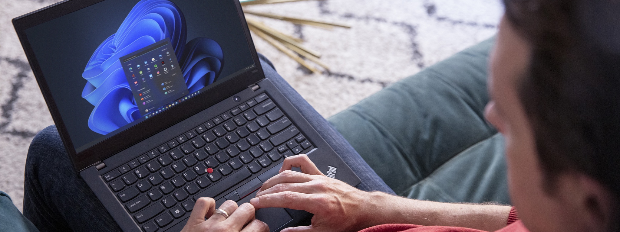 Immagine di un uomo che lavora al suo laptop a casa, mentre personalizza la schermata iniziale di Windows 11