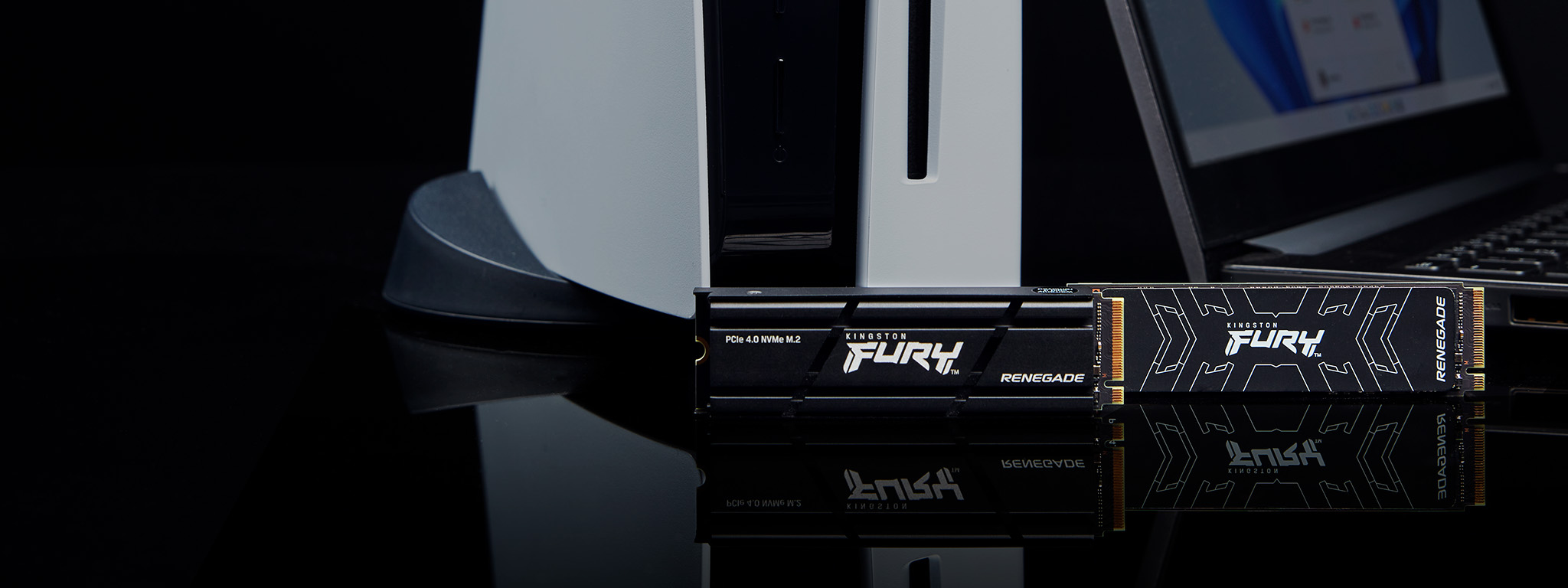 Zwei Kingston FURY Renegade SSDs, mit und ohne Heatsink, stehen neben einer PS5 und einem Laptop.