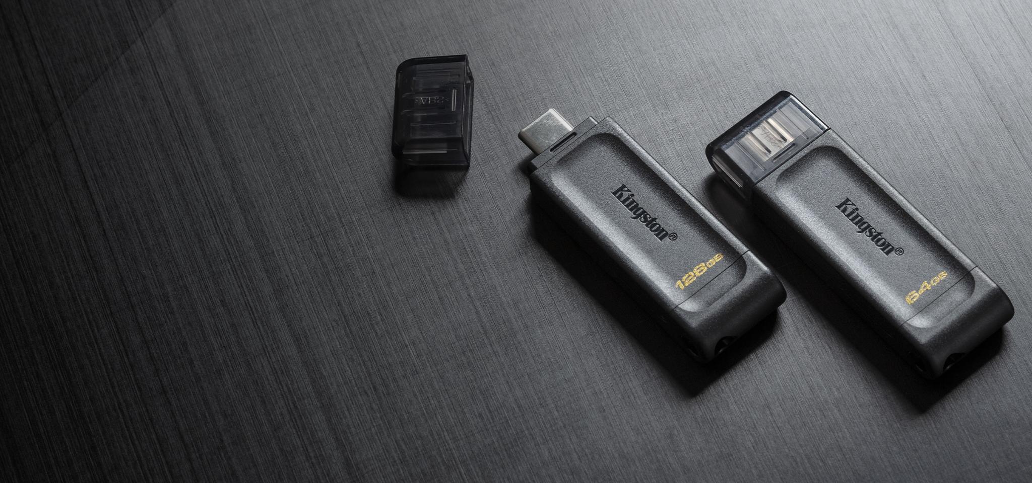 A pair of DT70 USB flash drives sit on a textile surface