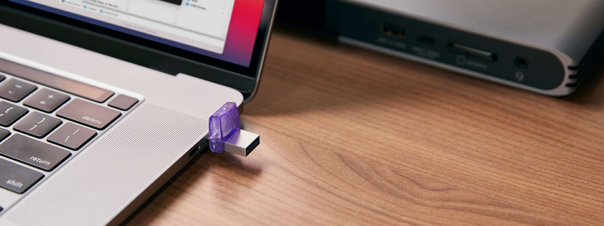 Une clé USB DT MicroDuo 3C connectée au côté droit d’un ordinateur portable sur un bureau