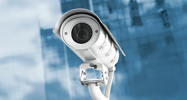 A security camera with a building in the background.