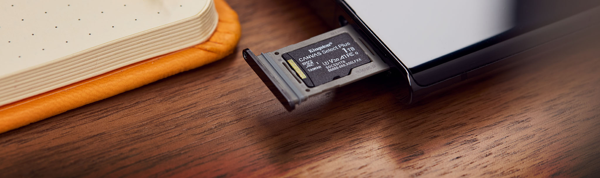 A 1TB Canvas Select Plus microSD sits in a tray ejected from   mobile device