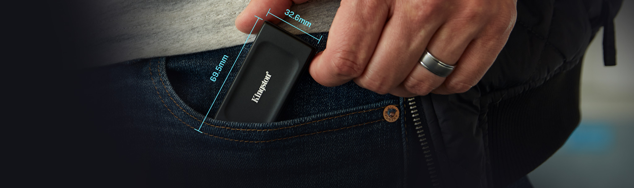 A hand holding the XS1000 portable SSD with the dimensions shown: 69.54 x 32.58 x 13.5mm