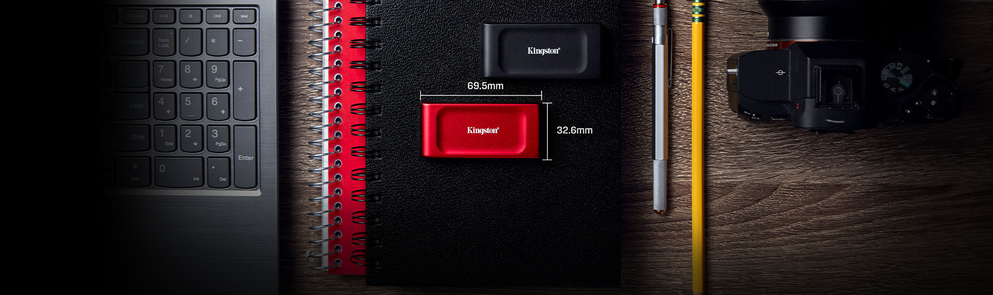 A hand holding the XS1000 portable SSD with the dimensions shown: 69.54 x 32.58 x 13.5mm