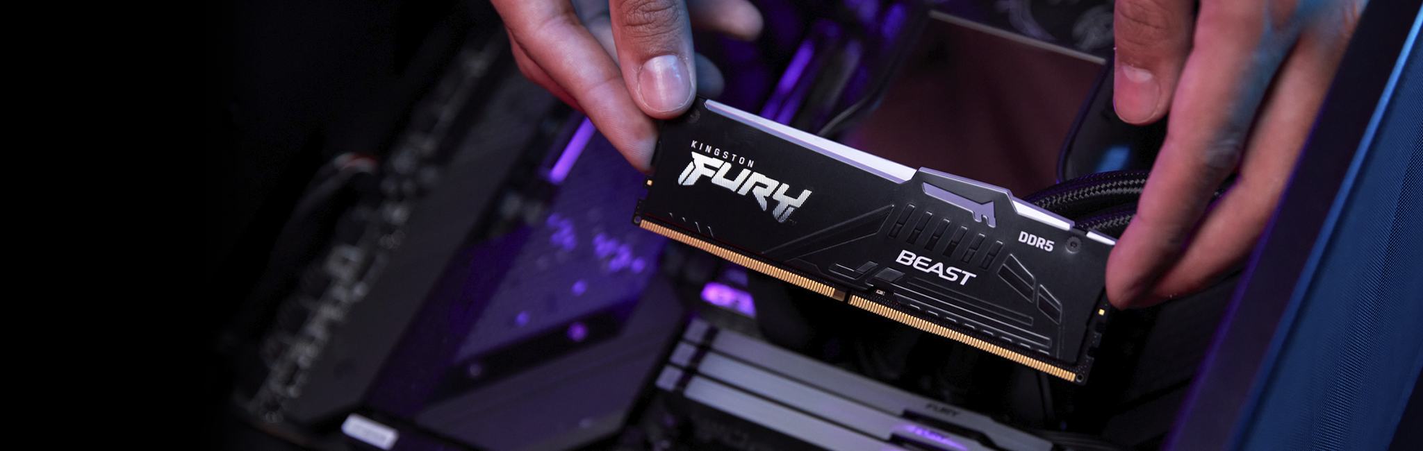 a hand installing Kingston FURY Beast DDR5 RGB into a PC motherboard